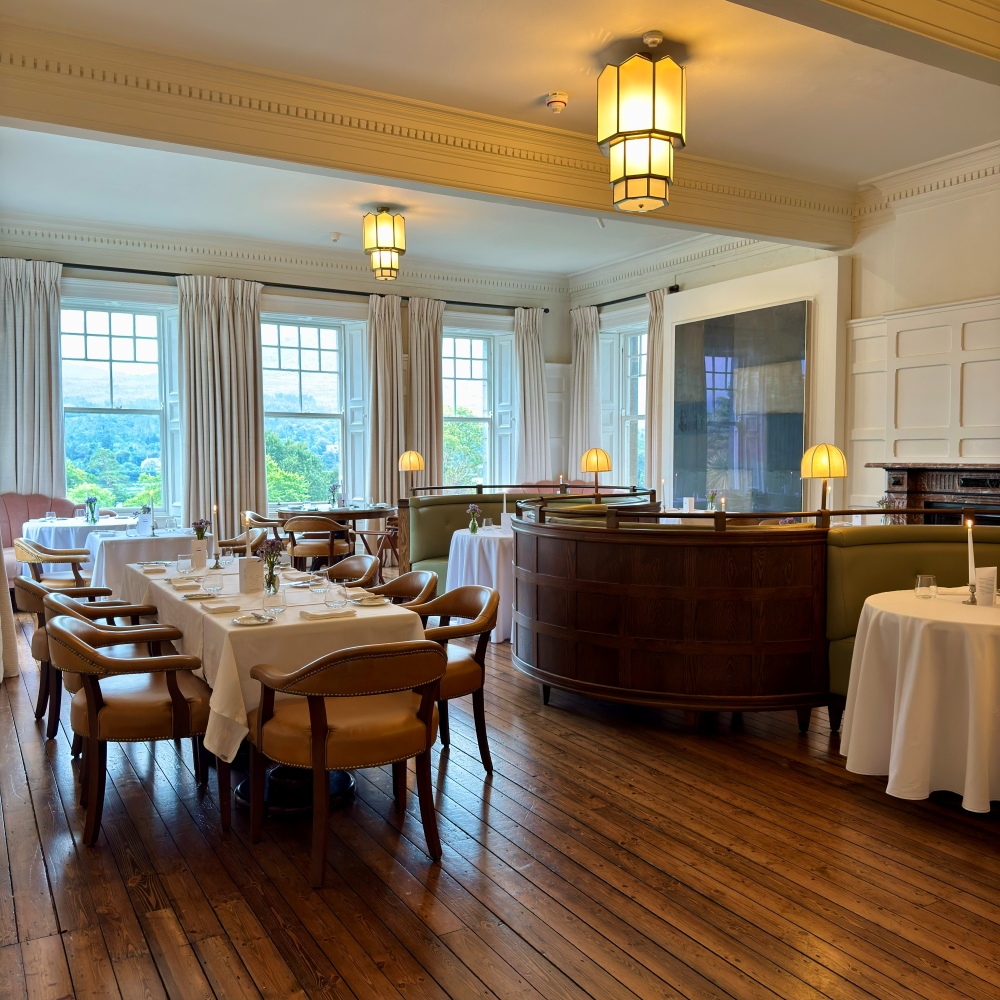 Elegant dining room at Landline restaurant at Park Hotel Kenmare with wooden floors, tables and views of the gardens in County Kerry, Ireland